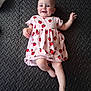 Leia joined the competition — help win amazing prizes! baby, child, pink_dress, strawberry_pattern, smiling, lying_down, barefoot, blue_eyes, short_hair, floor_mat, black_mat, texture, infant, cute, happy, indoor, person, one_child, casual_clothing, playtime