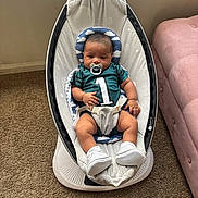 Aziel is registered to the contest to win money with this photo: baby, infant, pacifier, baby_rocker, carpet, jersey, number_one, headrest, sock, shoe, indoor, couch, plush, person, child, relaxing, comfort, seated, furniture, soft_lighting