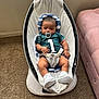 baby, infant, pacifier, baby_rocker, carpet, jersey, number_one, headrest, sock, shoe, indoor, couch, plush, person, child, relaxing, comfort, seated, furniture, soft_lighting