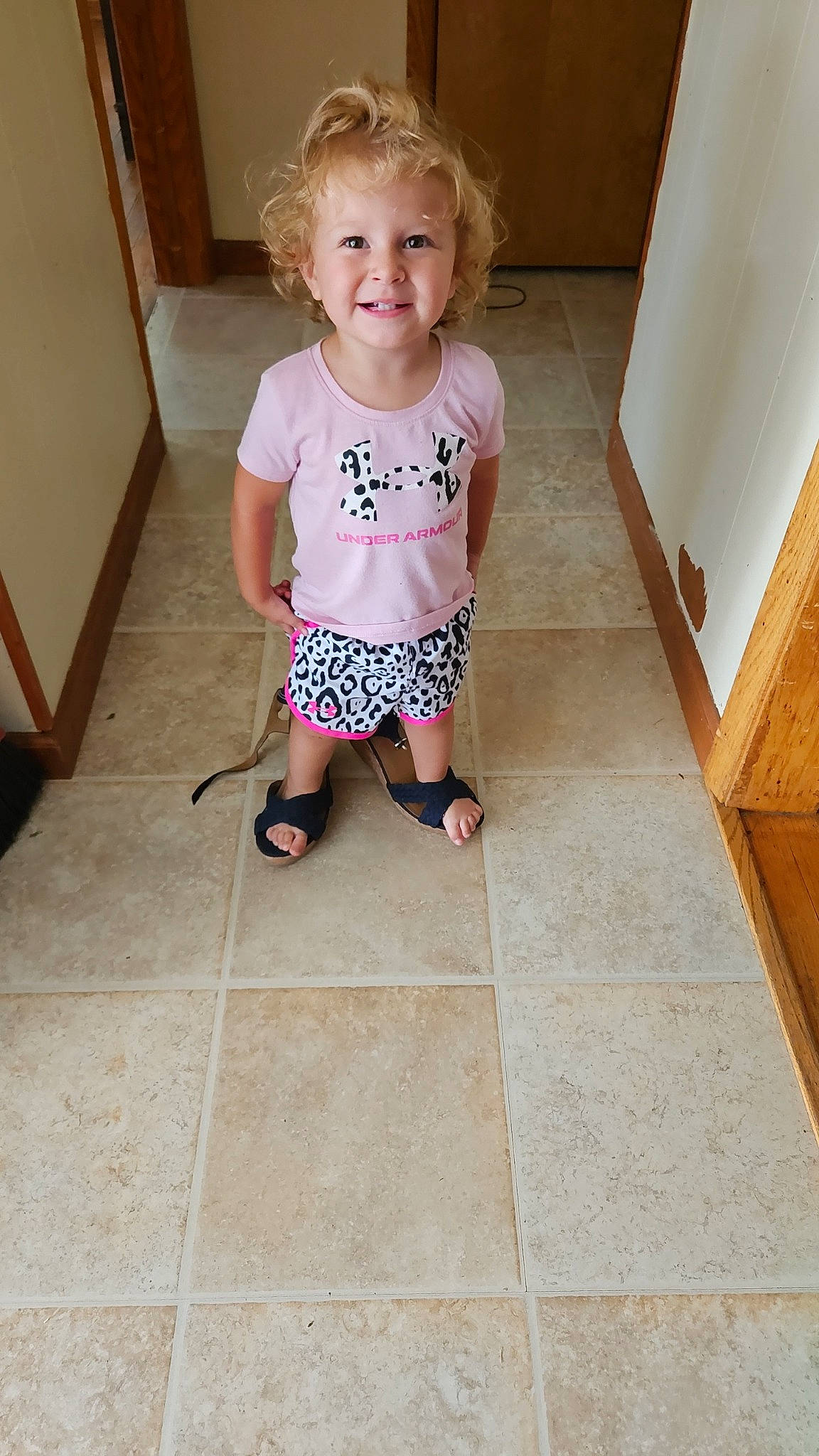 Adaliyah is registered to the contest to win money with this photo: baby_toddler_clothing, child, clothing, door, floor, flooring, foot, hardwood, human_leg, joy, knee, leg, pattern, person, rectangle, sitting, sleeve, smile, t_shirt, toddler
