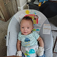 Ocean is registered to the contest to win money with this photo: baby, infant, mittens, baby_seat, rainbow, sun, monkey, carpet, hand, indoor, clothing, cute, smiling, person, furniture, wood, toy, seat, happy, child