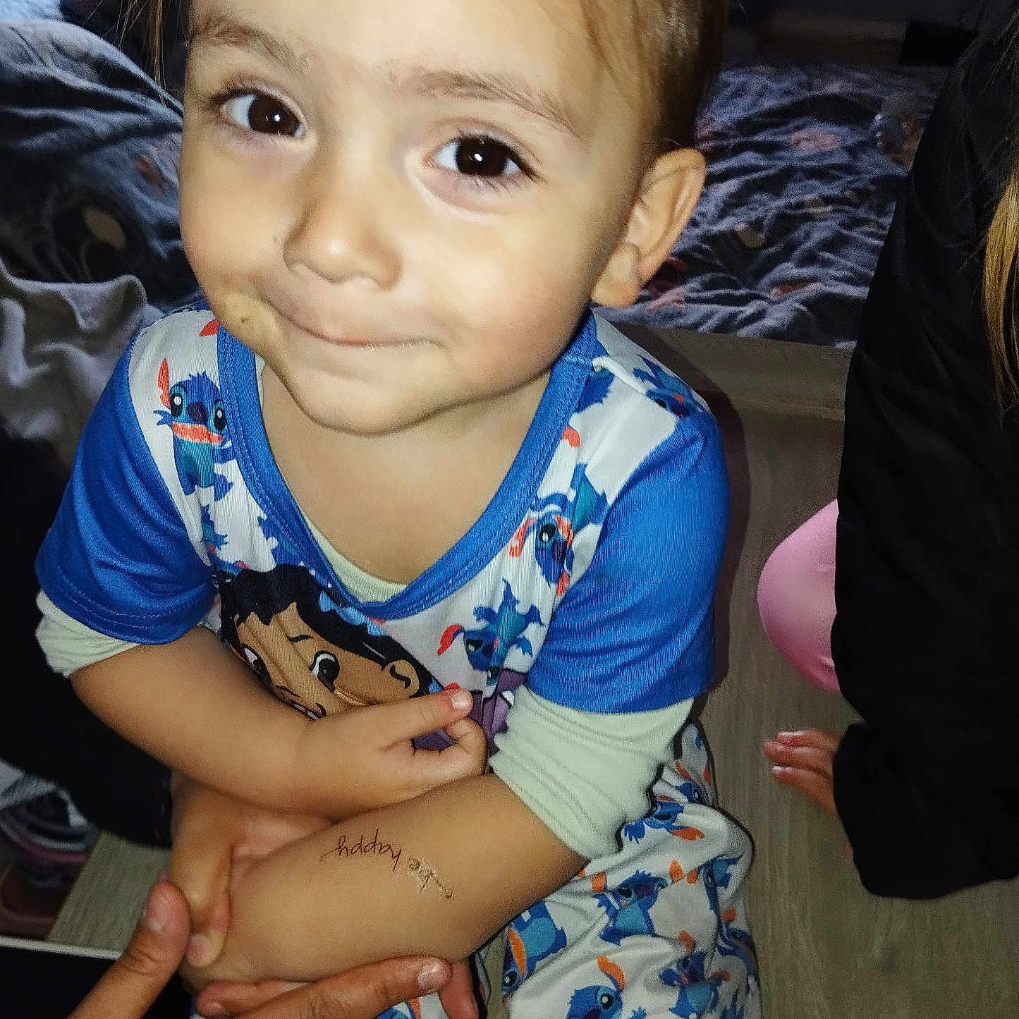 Jacye a rejoint le concours — aidez-le/la à gagner de superbes lots ! bedroom, blanket, child, clothing, colorful, cute, drawing, eyes, face, hand, indoor, long_sleeves, pajamas, person, sitting, skin, smile, temporary_tattoo, toddler, young_child