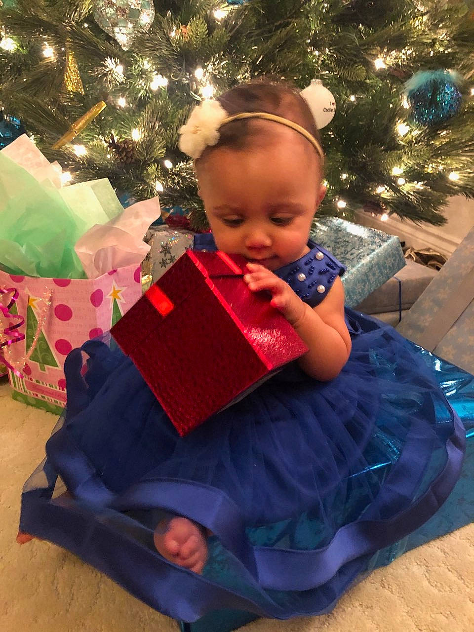 Jolene is registered to the contest to win money with this photo: baby, baby_toddler_clothing, child, christmas, christmas_decoration, christmas_eve, christmas_lights, christmas_ornament, christmas_tree, conifer, costume_accessory, fictional_character, gift_wrapping, holiday, holiday_ornament, interior_design, ornament, party_supply, person, present