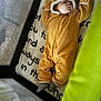 baby, sleeping, onesie, brown, bear_ears, blanket, playpen, sock, infant, cozy, child, soft, cute, resting, indoors, text, fabric, mesh, green, peaceful