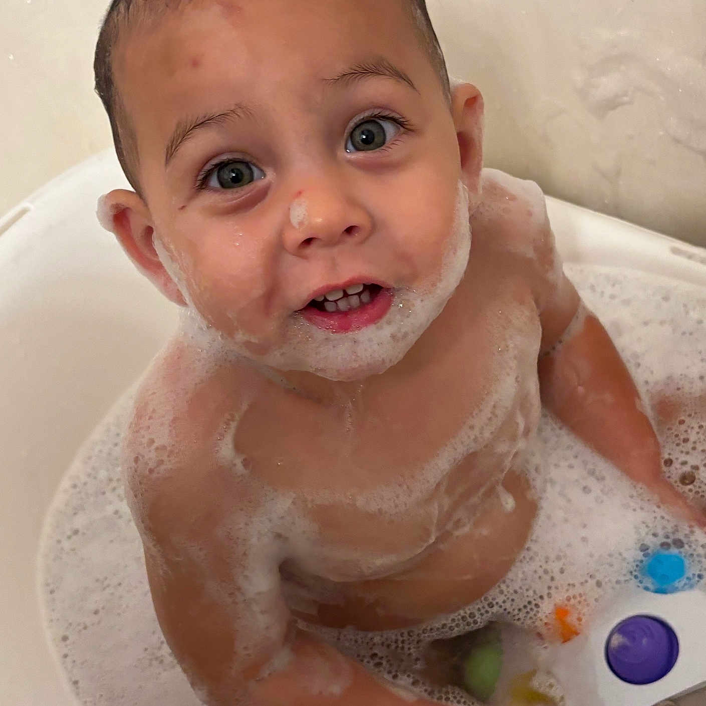 Lucas is registered to the contest to win money with this photo: baby, bath, bathtub, bubbles, child, cute, eyes, face, foam, indoors, mouth, person, playful, skin, smiling, soap, toddler, toy, water, wet_hair