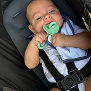 Lucas is registered to the contest to win money with this photo: baby, infant, car_seat, teether, pacifier, baby_clothing, straps, black_straps, soft_toy, blanket, cute, child, holding, closeup, skin, face, hand, comfort, indoor, seat