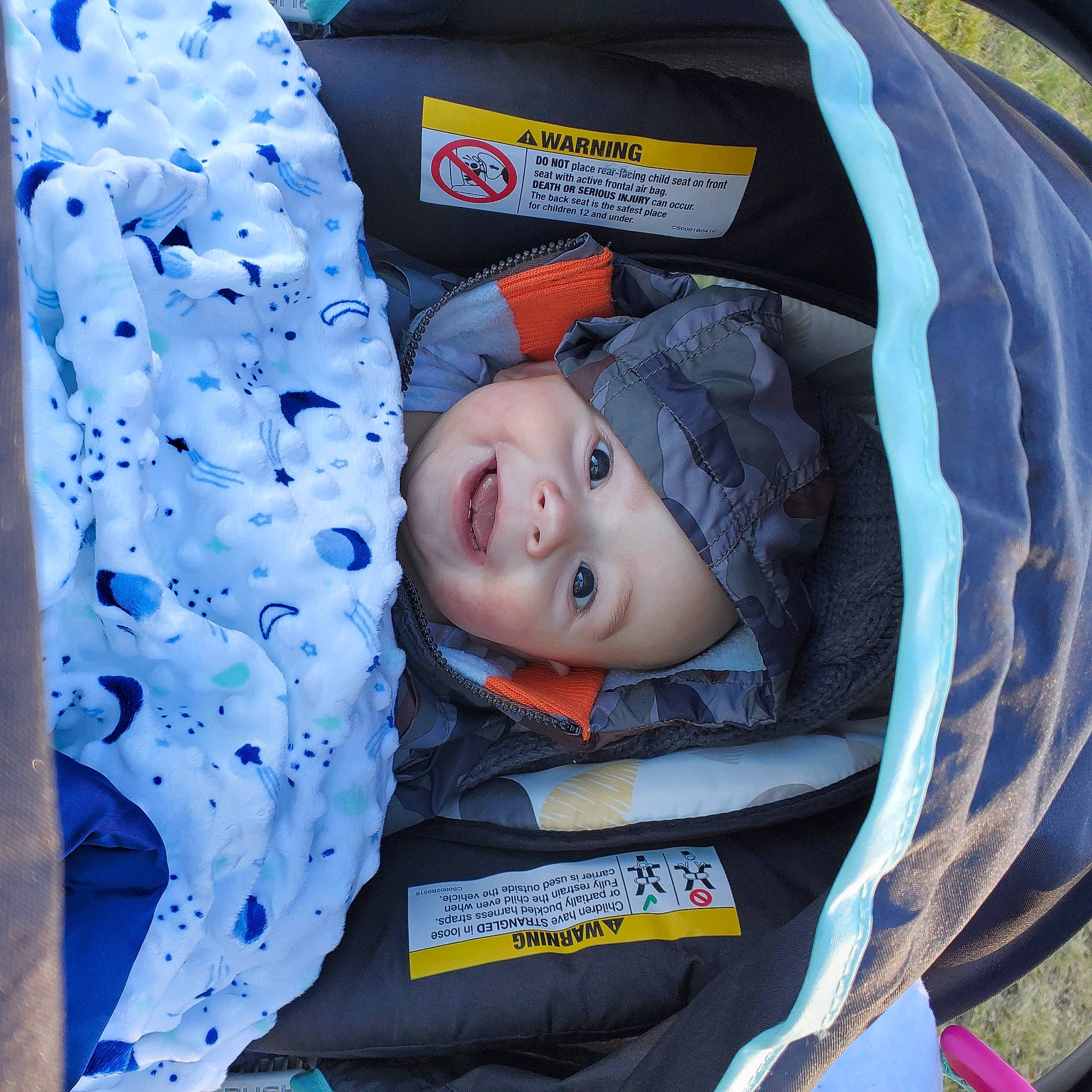 Conrad is registered to the contest to win money with this photo: baby, baby_carriage, baby_products, baby_safety, baby_toddler_clothing, blue, car_seat, child, comfort, electric_blue, eye, fashion_accessory, headwear, linens, orange, pattern, person, plastic, product, smile