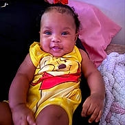 Aunesty joined the competition — help win amazing prizes! baby, child, smile, red_bow, yellow_outfit, winnie_the_pooh, sitting, person, blanket, bedding, indoor, happy, cute, portrait, infant, clothing, hand, face, head, cozy