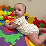 Aurora is registered to the contest to win money with this photo: baby, child, infant, onesie, colorful_mat, foam_puzzle, plastic_balls, play_area, indoor, cute, curious, childrens_toy, floor, soft_surface, head, face, skin, hand, leg, person
