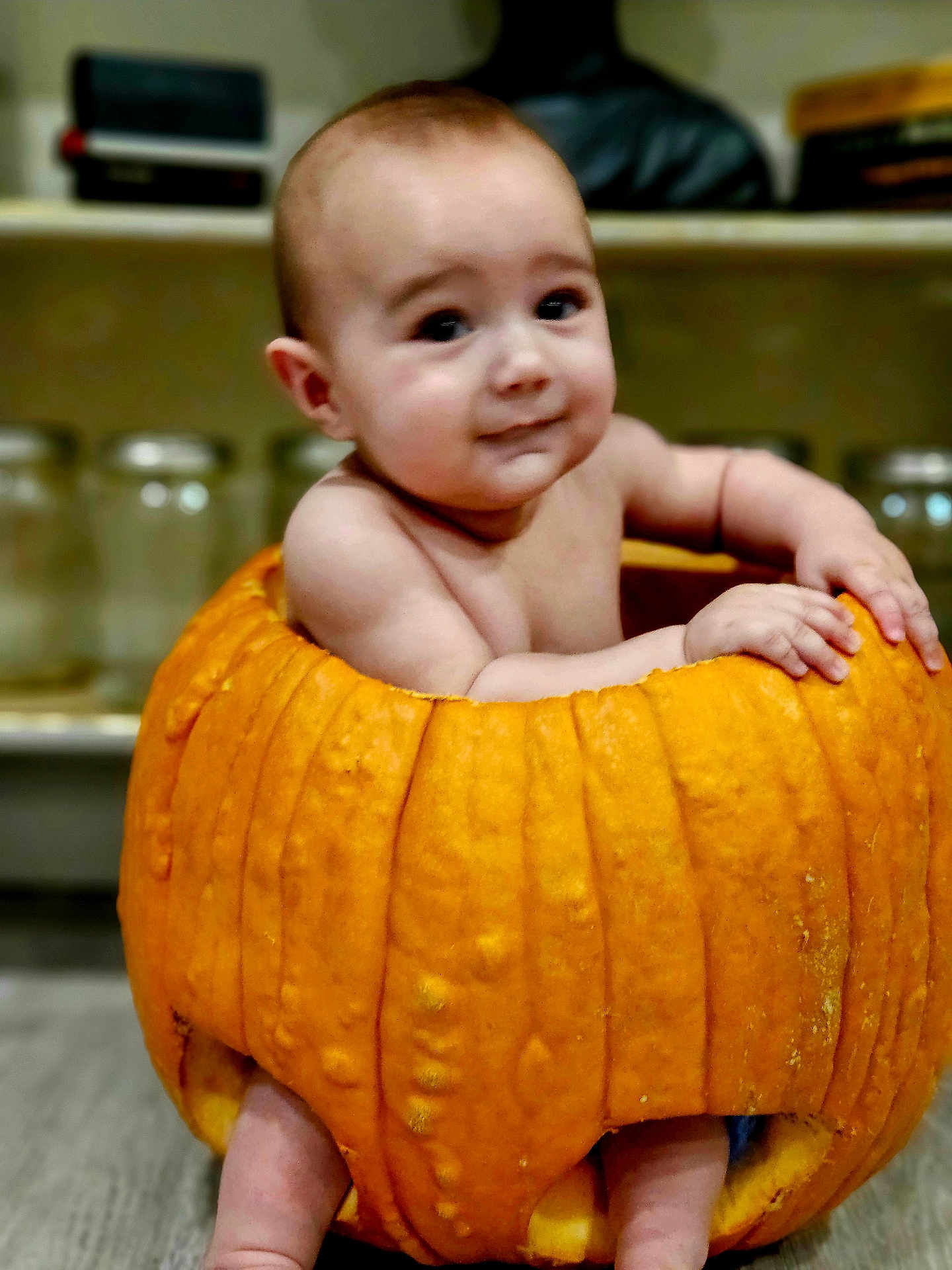 Ezekiel joined the competition — help win amazing prizes! baby, pumpkin, child, kitchen, jar, sitting, orange, cute, skin, face, expression, indoors, food, vegetable, holiday, autumn, smile, hands, legs, background