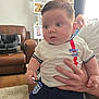 baby, child, person, hand, clothing, indoor, living_room, carpet, couch, photography, portrait, smile, furniture, sportswear, football, england, window, curtain, family, home