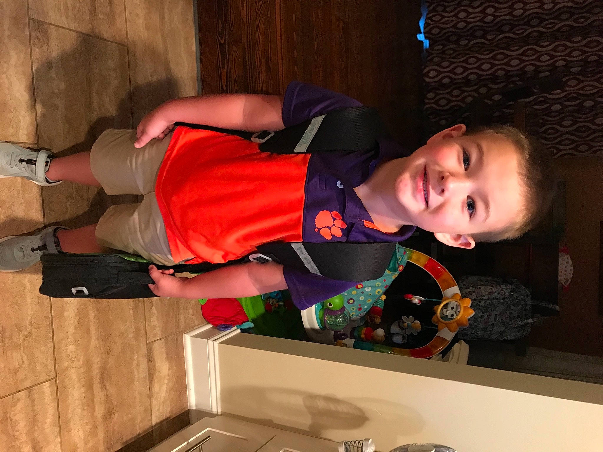 Coleman is registered to the contest to win money with this photo: boot, elbow, fun, human_leg, joy, knee, leg, orange, person, room, shorts, sleeve, smile, sock, sportswear, t_shirt, thigh, toddler, walking_shoe, wrist