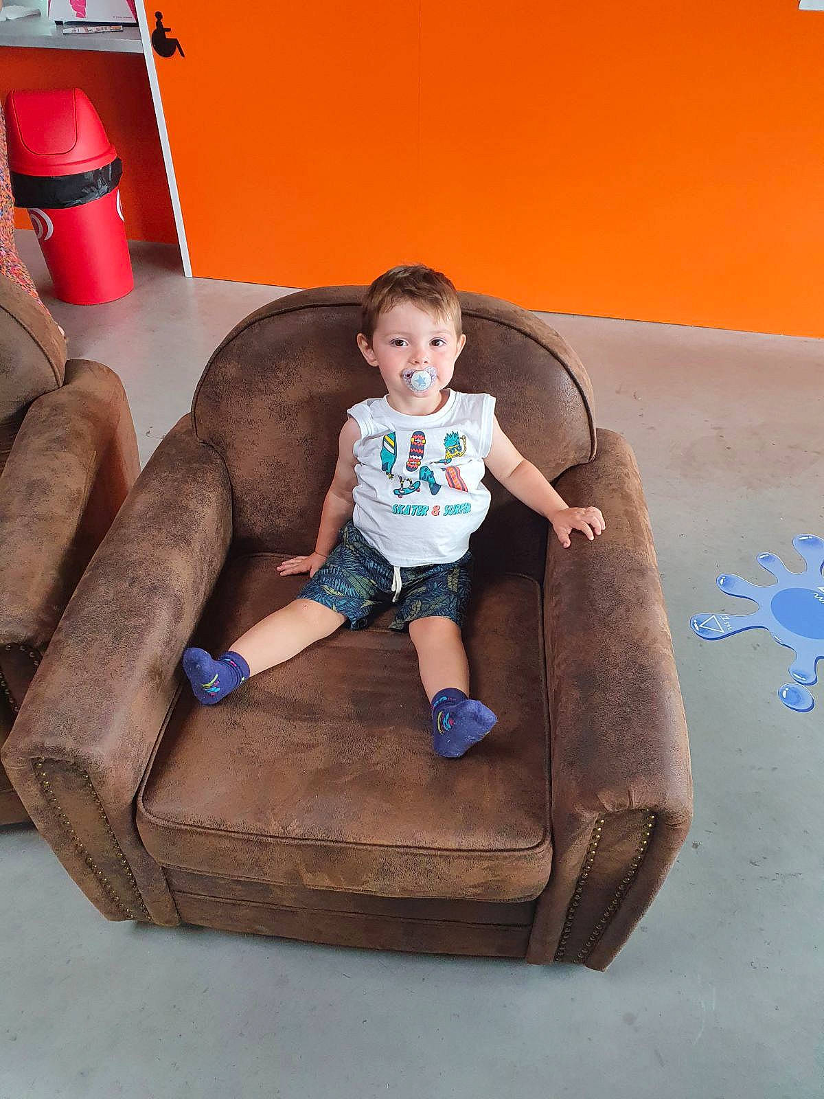 Lyvio a rejoint le concours — aidez-le/la à gagner de superbes lots ! baby, baby_toddler_clothing, child, comfort, flooring, foot, fun, hardwood, human_leg, knee, person, rectangle, room, shorts, sitting, sleeve, sock, t_shirt, thigh, toddler