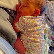 Faith is registered to the contest to win money with this photo: baby, sleeping, infant, floral_onesie, blanket, bed, cozy, newborn, peaceful, face, hand, skin, soft, resting, cute, indoors, comfort, child, person, toddler