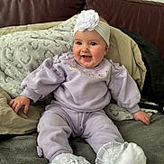 Dolcie-Rae joined the competition — help win amazing prizes! baby, blanket, child, comfortable, couch, cozy, cute, flower, happy, headband, indoors, infant, person, portrait, purple_clothing, sitting, smiling, soft_fabric, white_socks, young_child