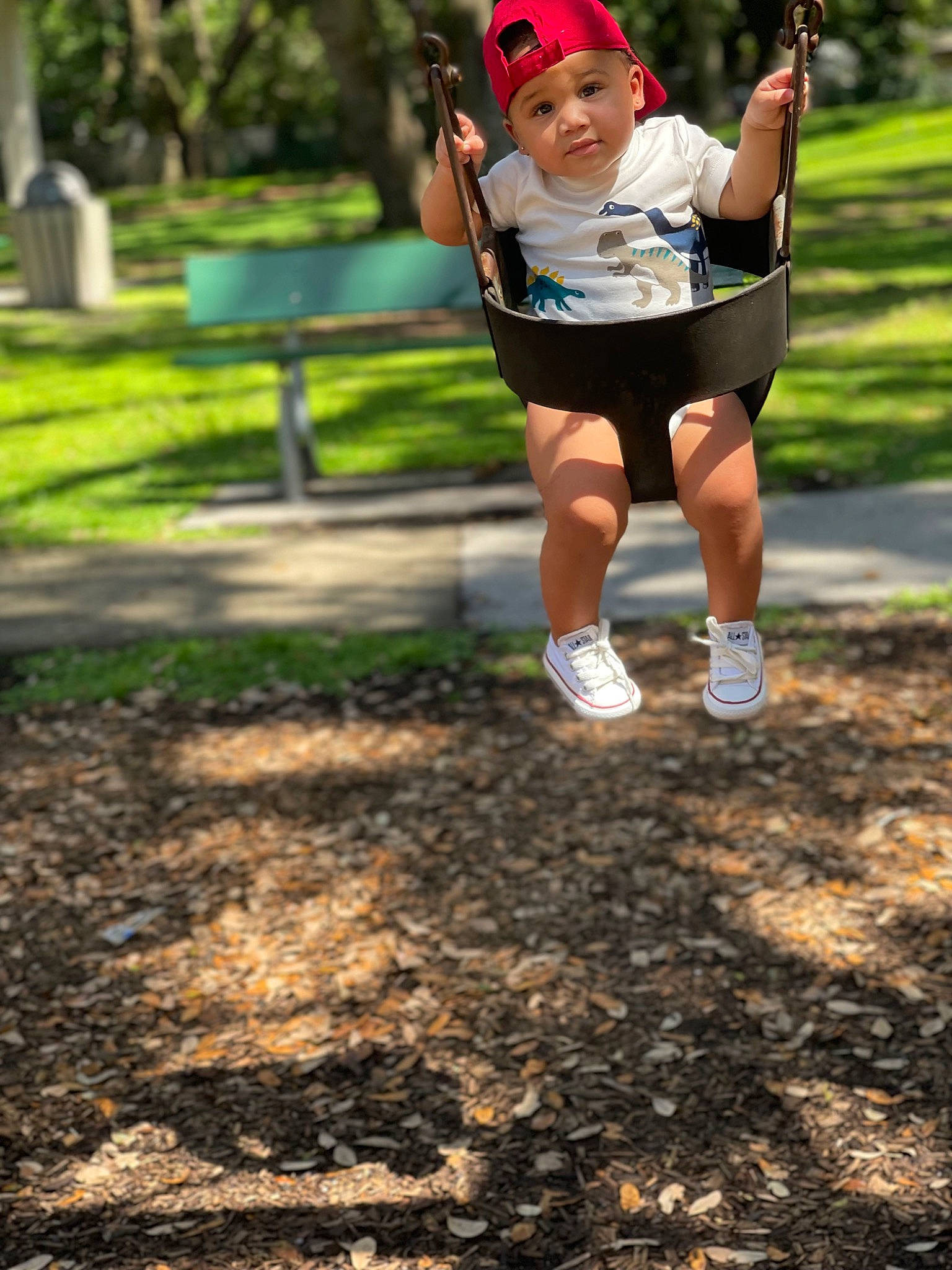Kareem is registered to the contest to win money with this photo: baseball_cap, child, city, fun, grass, happy, hat, headwear, leisure, outdoor_play_equipment, people_in_nature, person, plant, playground, recreation, shorts, soil, sun_hat, swing, t_shirt