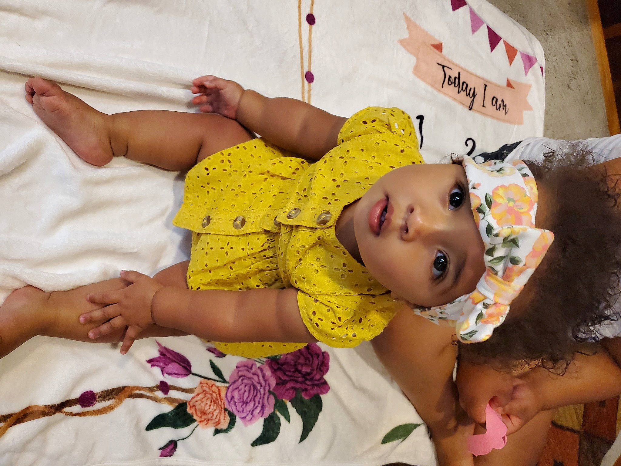 Anayah is registered to the contest to win money with this photo: abdomen, baby, baby_toddler_clothing, bed, child, comfort, event, flower, fun, happy, hat, headwear, linens, magenta, pattern, person, pink, room, skin, textile