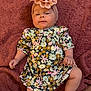 Brileigh joined the competition — help win amazing prizes! baby, infant, child, floral_dress, headband, flower, blanket, skin, legs, arms, person, cute, lying_down, indoors, soft_texture, pink, brown, happy, playful, toddler
