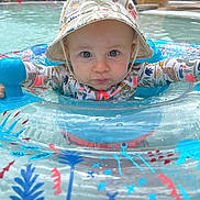 Marlo a rejoint le concours — aidez-le/la à gagner de superbes lots ! baby, child, pool, water, inflatable_ring, hat, swimming, summer, outdoor, blue, red, pattern, float, person, splash, play, fun, face, expression, sunhat