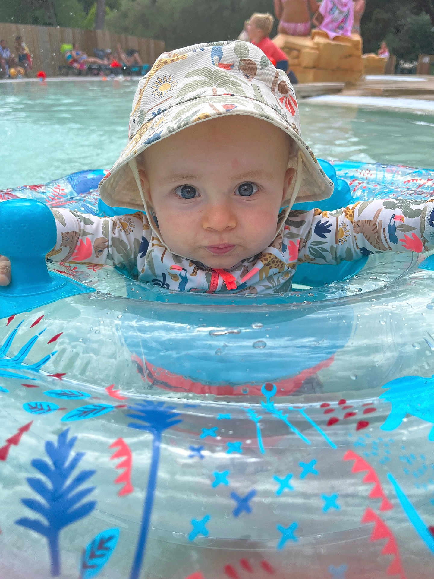 Marlo a rejoint le concours — aidez-le/la à gagner de superbes lots ! baby, child, pool, water, inflatable_ring, hat, swimming, summer, outdoor, blue, red, pattern, float, person, splash, play, fun, face, expression, sunhat