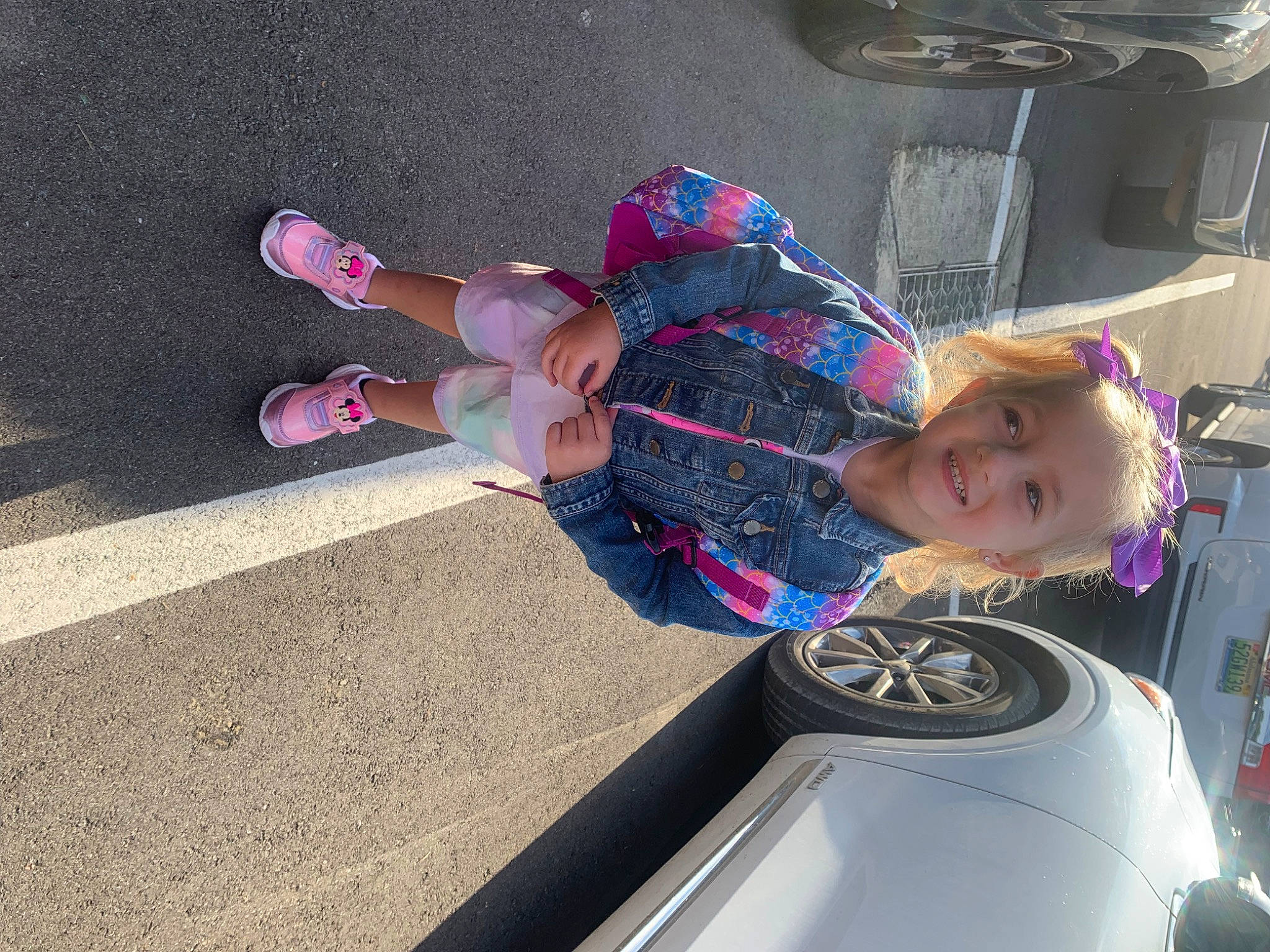 Kynlee is registered to the contest to win money with this photo: automotive_exterior, automotive_lighting, automotive_tire, bumper, car, cool, fender, hood, joy, motor_vehicle, person, pink, rim, smile, sneakers, tire, toddler, trunk, vehicle, vehicle_door