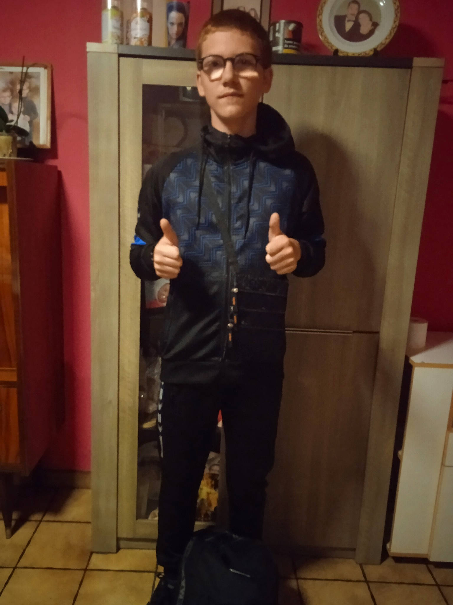 Anzo participe au concours pour gagner de l'argent avec cette photo : bag, blazer, button, denim, door, event, eyewear, fashion_design, formal_wear, hat, jewellery, luggage_and_bags, necklace, person, picture_frame, room, sleeve, standing, suit, vision_care