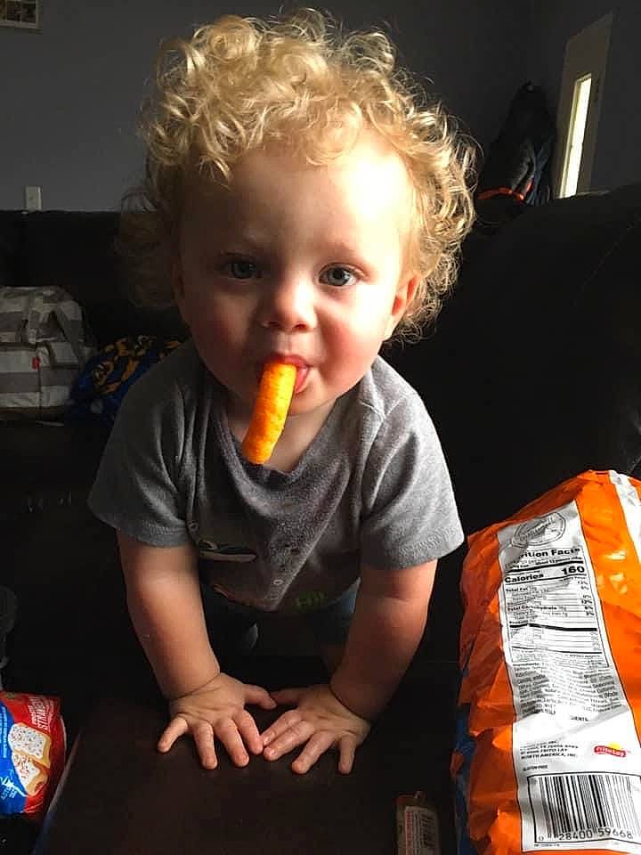 Carlos is registered to the contest to win money with this photo: american_food, baby, biting, child, comfort_food, cuisine, eating, finger_food, food, food_craving, fun, junk_food, meal, person, play, room, sharing, sitting, sweetness, t_shirt