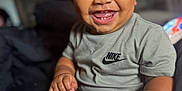 Zamari is registered to the contest to win money with this photo: toddler, child, smiling, happy, curly_hair, nike, tshirt, portrait, indoor, baby, cute, sitting, skin, person, face, hand, foot, expression, young_child, closeup