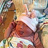 Autumn is registered to the contest to win money with this photo: newborn, baby, infant, sleeping, tongue_out, pink_hat, bunny_ears, blanket, hospital_bassinet, cute, peaceful, child, wrapped, clothing, soft, indoor, person, portrait, resting, tiny