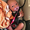 baby, pacifier, car_seat, blanket, infant, child, seatbelt, cute, indoor, soft, pink, orange, clothing, person, newborn, hands, feet, safety, closeup, portrait