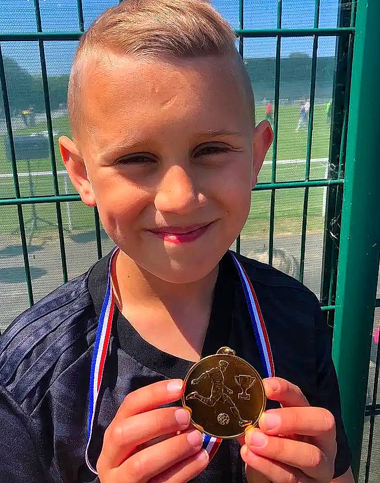 Karim a rejoint le concours — aidez-le/la à gagner de superbes lots ! bronze_medal, child, chin, chocolate, dessert, electric_blue, fashion_accessory, fence, finger, finger_food, fun, hairstyle, happy, joy, medal, person, sky, smile, thumb, toddler