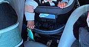 Yamin is registered to the contest to win money with this photo: adult, baby, car_interior, car_seat, child, clothing, face, hand, head, jacket, leather_seat, person, road, seat, seatbelt, toy, travel, vehicle, window, winter_wear