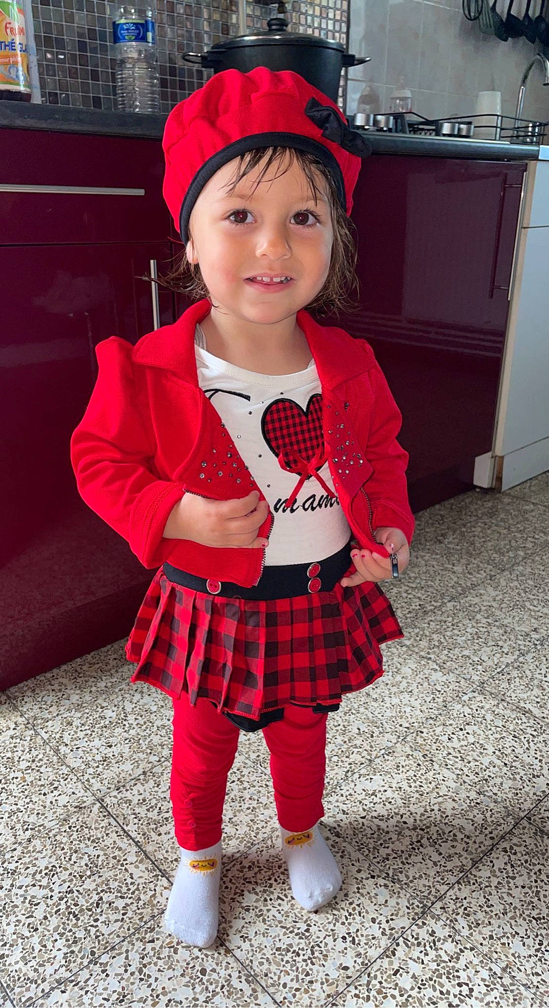 Lilou participe au concours pour gagner de l'argent avec cette photo : cap, clothing, collar, face, facial_expression, hair, hat, headgear, headwear, human_body, joy, outerwear, person, pink, plaid, red, sleeve, smile, sock, standing