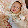 baby, smiling, infant, blanket, heart_pattern, onesie, cute, soft, cozy, child, portrait, happy, indoors, warm, comfort, person, face, pink, fabric, sleepwear