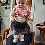 Ava joined the competition — help win amazing prizes! baby, child, infant, headband, bunny_ears, pink_bib, striped_leggings, fluffy_boots, black_skirt, white_shirt, person, holding, kitchen, chair, wooden_furniture, pots, utensils, indoor, cute, smiling