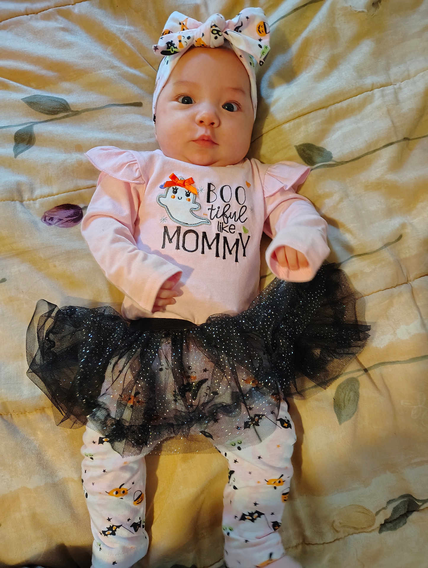 Ava joined the competition — help win amazing prizes! baby, infant, child, clothing, headband, tutu, black_tutu, long_sleeve_shirt, leggings, bedspread, patterned_clothes, cute, halloween_theme, lying_down, indoors, expression, face, hands, feet, soft_lighting