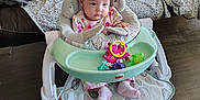Ava joined the competition — help win amazing prizes! baby, infant, baby_chair, toy, pink_clothing, polka_dot, face, expression, couch, blanket, dog_tail, dog_leg, carpet, wooden_table, indoor, home, furniture, person, child, seated