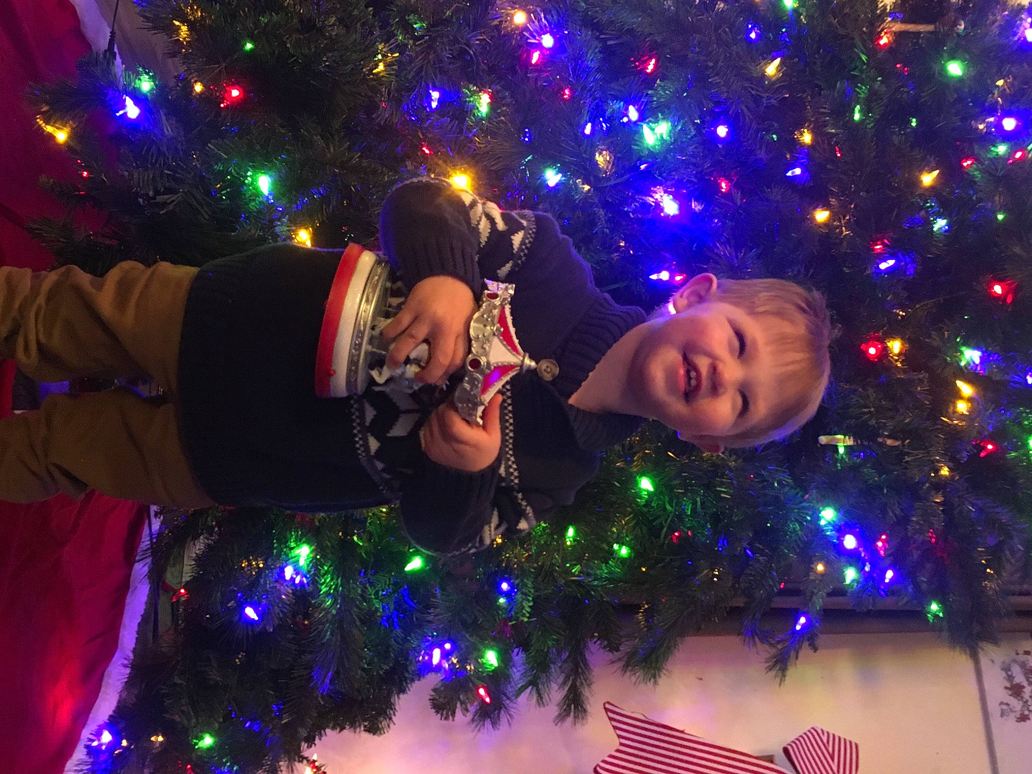 Noah is registered to the contest to win money with this photo: blue, christmas_decoration, christmas_ornament, christmas_tree, entertainment, fun, hair, happy, head, holiday_ornament, human_body, joy, light, lighting, midnight, ornament, people, person, plant, purple