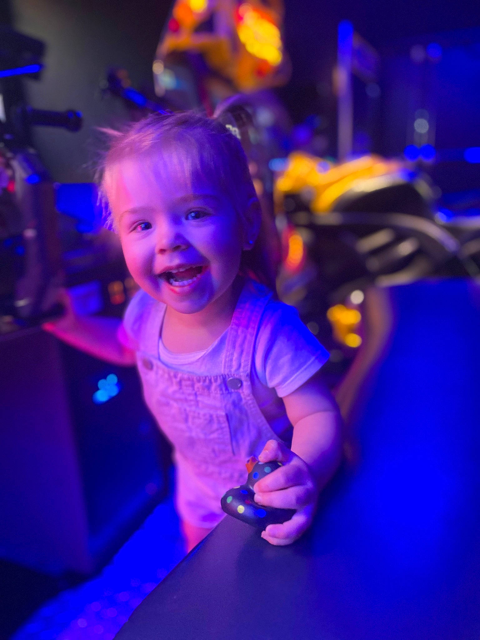 Charlotte is registered to the contest to win money with this photo: child, electric_blue, entertainment, event, face, flash_photography, fun, gesture, hairstyle, hand, happy, human_body, joy, leisure, magenta, neon, performing_arts, person, purple, smile