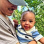 baby, child, person, smile, tongue_out, cap, short_sleeve, striped_shirt, horse_logo, outdoor, nature, greenery, arm, holding, happy, portrait, close_up, daylight, casual, affection