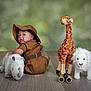 Zenith is registered to the contest to win money with this photo: baby, child, plush_toy, stuffed_animal, rhino, giraffe, lion, binoculars, safari_outfit, hat, wooden_floor, indoor, portrait, cute, looking_back, green_background, flooring, toy, young_child, animal_toys