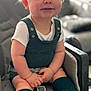 baby, child, infant, blue_eyes, knitted_clothing, green_socks, green_outfit, seat, cushion, indoor, portrait, smiling, cute, hands, legs, comfort, soft_lighting, closeup, young_child, casual_clothing