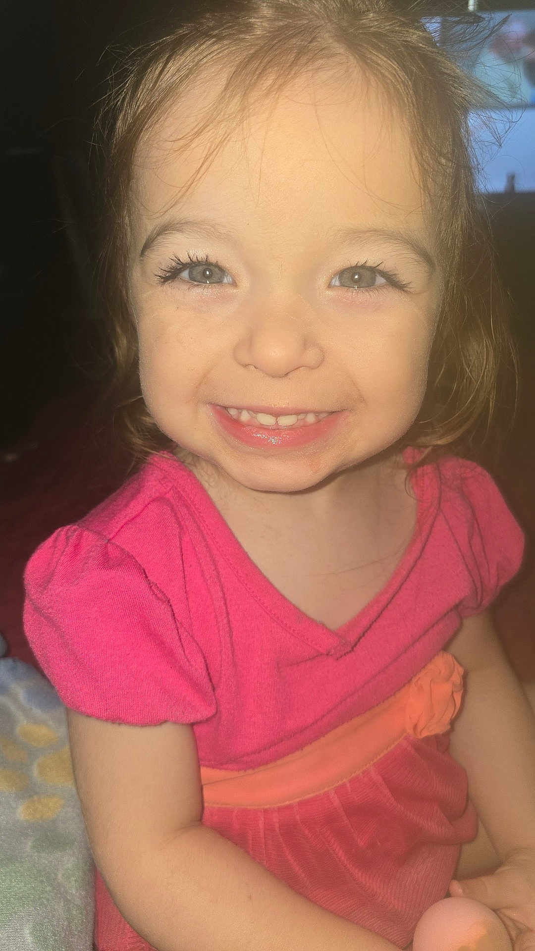 Chloe is registered to the contest to win money with this photo: child, toddler, smiling, face, dress, pink_clothing, happy, portrait, person, young_child, eyelashes, hair, indoors, cute, baby, skin, hand, sitting, light, closeup