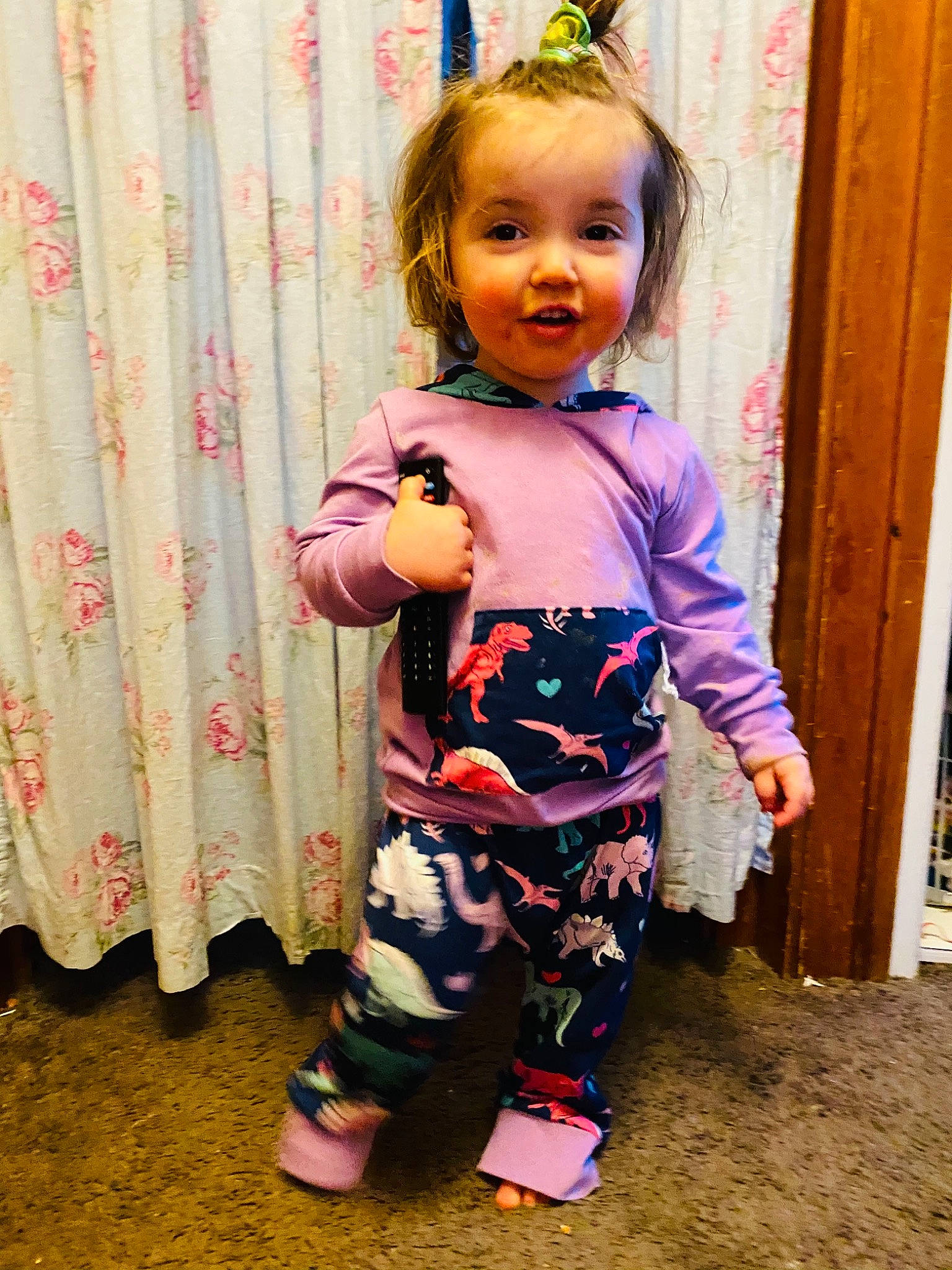 Piper is registered to the contest to win money with this photo: baby, baby_toddler_clothing, cheek, child, curtain, dress, face, fun, happy, head, magenta, pattern, person, pink, product, purple, skin, sleeve, smile, standing