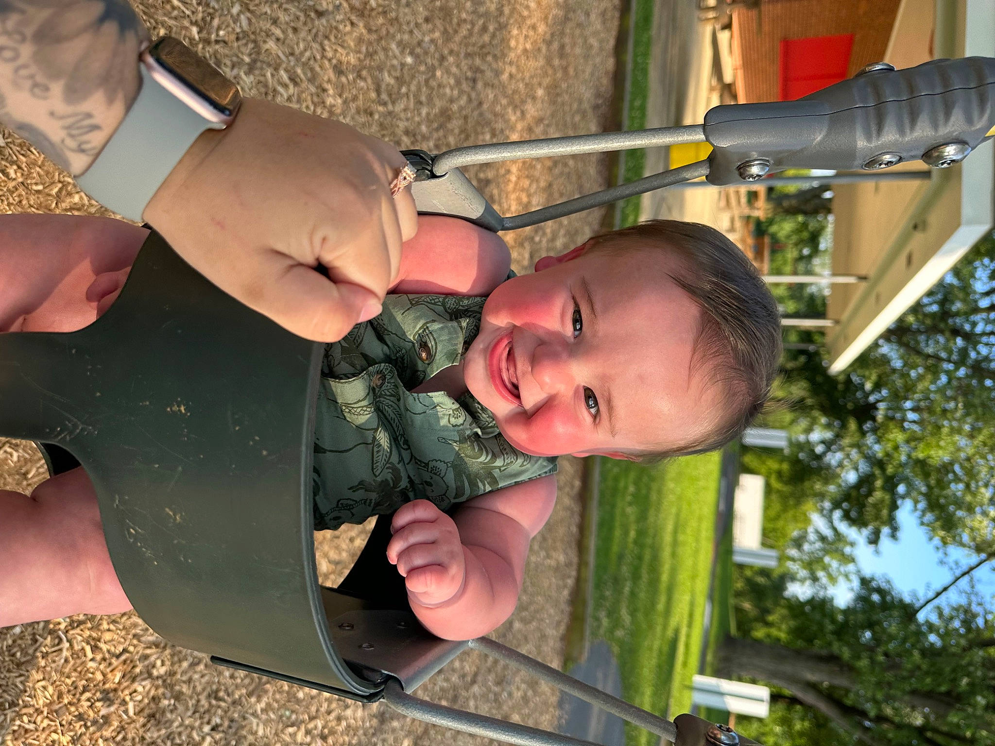 Colton joined the competition — help win amazing prizes! baby, child, fun, gesture, grass, green, happy, joy, leisure, light, mouth, outdoor_play_equipment, people_in_nature, person, plant, playground, recreation, smile, swing, thumb