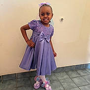Anaiyiah is registered to the contest to win money with this photo: child, girl, purple_dress, bow, headband, smile, pose, shoes, ribbons, tights, earrings, indoor, tile_floor, wall, happy, fashion, portrait, cute, person, standing
