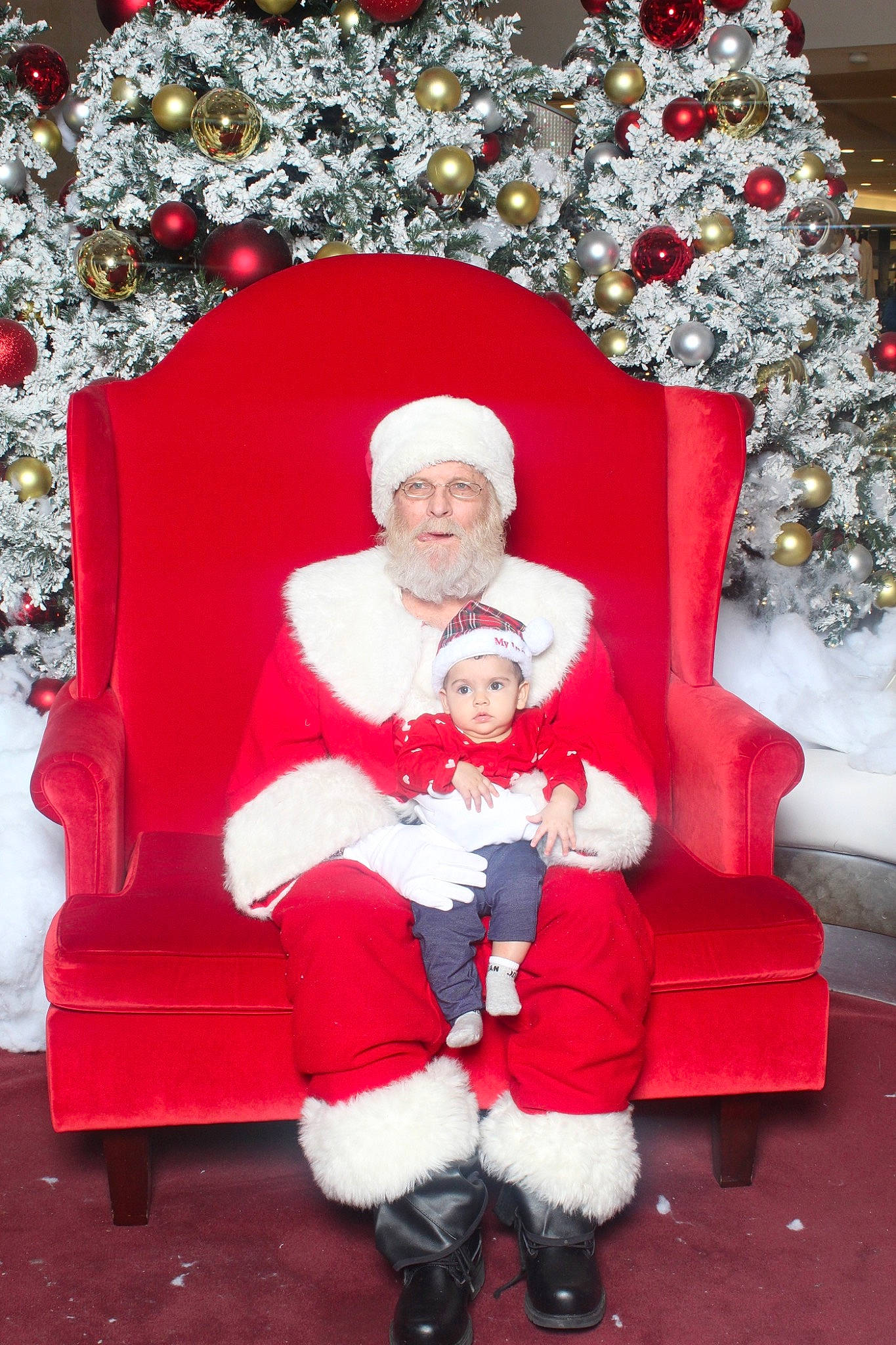 Sukhmani joined the competition — help win amazing prizes! beard, christmas, christmas_decoration, christmas_eve, christmas_ornament, event, fictional_character, happy, hat, headwear, holiday, holiday_ornament, lap, ornament, person, red, santa_claus, sitting, smile, toddler