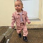 Julia participe au concours pour gagner de l'argent avec cette photo : toddler, child, pink_jacket, pink_pants, black_boots, bow, hair_accessory, outdoor, pavement, door, concrete, sidewalk, walking, serious_expression, young_child, person, clothing, footwear, curly_hair, casual