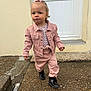 toddler, child, pink_jacket, pink_pants, black_boots, bow, hair_accessory, outdoor, pavement, door, concrete, sidewalk, walking, serious_expression, young_child, person, clothing, footwear, curly_hair, casual