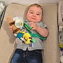 Alban participe au concours pour gagner de l'argent avec cette photo : baby, child, plush_toy, changing_pad, jeans, shirt, sock, indoor, floor, toy, infant, smiling, person, young_child, casual_clothing, relaxed, home, cute, lying_down, comfort